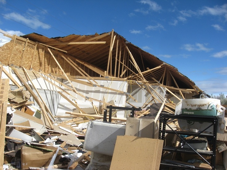 Wood-framed building damaged by impact from tractor-trailer.